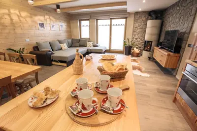 a living room with a table with plates of food on it at Apartments Krvavec in Cerklje na Gorenjskem