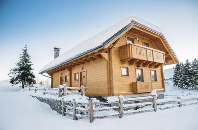 a log cabin in the snow with a fence at Apartments Krvavec in Cerklje na Gorenjskem