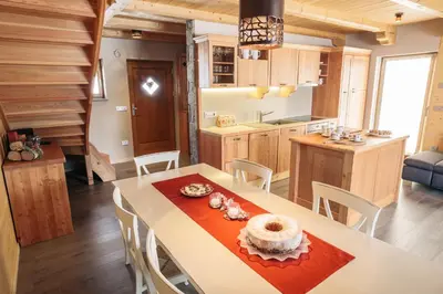 a kitchen and dining room with a table and chairs at Apartments Krvavec in Cerklje na Gorenjskem