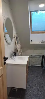 a bathroom with a sink and a mirror and a window at HIŠA Margit in Rateče