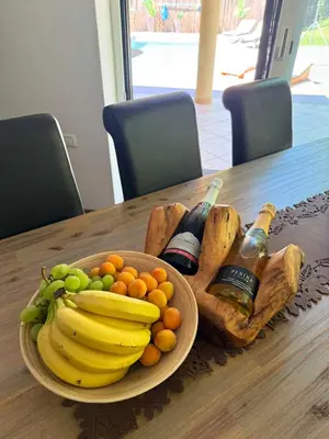 a plate of bananas and bottles of wine on a table at Vila Tin & Koča Tin in Prestranek