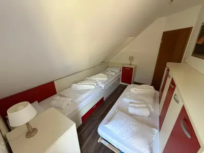 a small room with three beds and a lamp at Vila Tin & Koča Tin in Prestranek