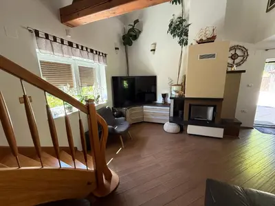 a living room with a staircase and a television at Vila Tin & Koča Tin in Prestranek