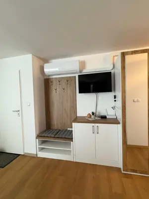 a small kitchen with white cabinets and a tv at Apartma Moravske Toplice 6 in Moravske Toplice
