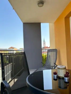 a table on a balcony with a view of the city at Apartma Moravske Toplice 6 in Moravske Toplice