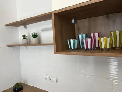 a row of colorful cups on a kitchen cabinet at Apartma Moravske Toplice 6 in Moravske Toplice