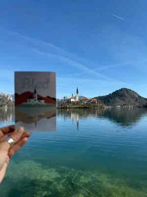 a person holding up a picture of a body of water at Katja Cottage in Bohinjska Bela