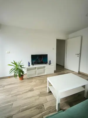 a living room with a tv and a white table at Apartment Mina in Radovljica