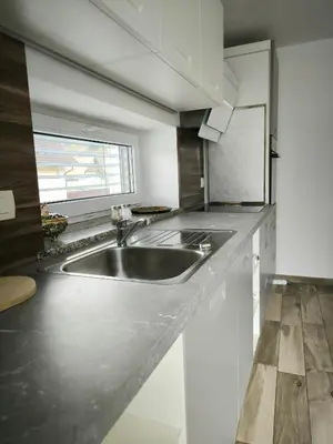 a kitchen with a stainless steel sink and a window at Apartment Mina in Radovljica
