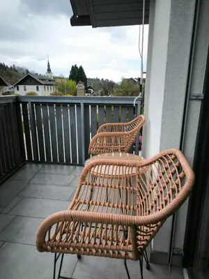 two wicker chairs sitting on top of a balcony at Apartment Mina in Radovljica