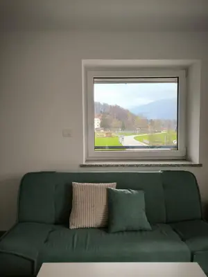 a green couch in a room with a window at Apartment Mina in Radovljica