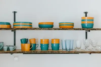 a bunch of bowls and glasses on shelves at Apartment MIDVA in Bled
