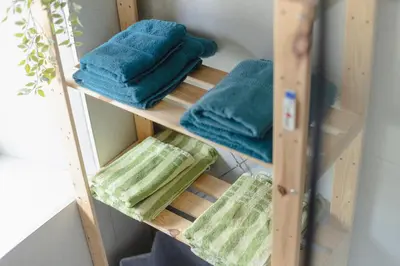a wooden towel shelf with blue towels on it at Apartment MIDVA in Bled