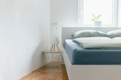 a bedroom with a blue bed and a window at Apartment MIDVA in Bled