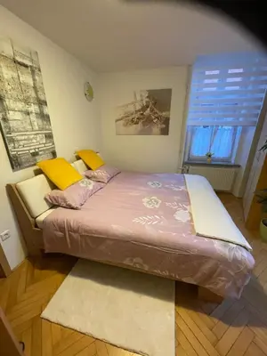 a large bed in a room with a window at Topel dom v središču mesta 2 in Maribor
