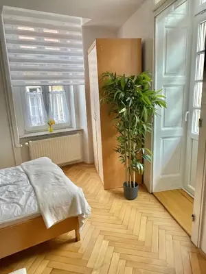 a bedroom with a bed and a potted plant at Topel dom v središču mesta 2 in Maribor