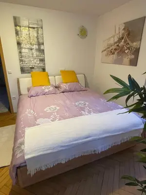a bedroom with a bed with two yellow pillows at Topel dom v središču mesta 2 in Maribor