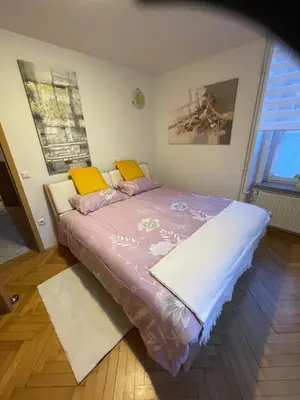 a bedroom with a purple bed with yellow pillows at Topel dom v središču mesta 2 in Maribor