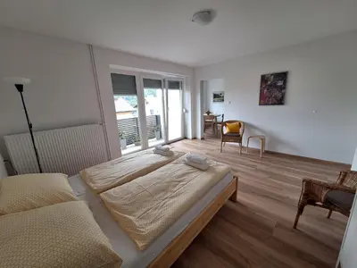 a bedroom with a large bed and a table and chair at SummerHouse in Jesenice