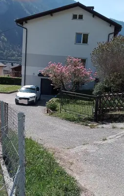 a car parked in front of a white house at SummerHouse in Jesenice