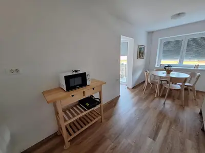 a kitchen and dining room with a table and a microwave at SummerHouse in Jesenice