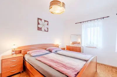 a bedroom with a bed with a dresser and a window at Penzion Hosnar in Bovec