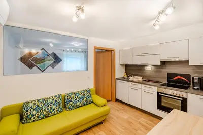 a living room with a yellow couch in a kitchen at Penzion Hosnar in Bovec