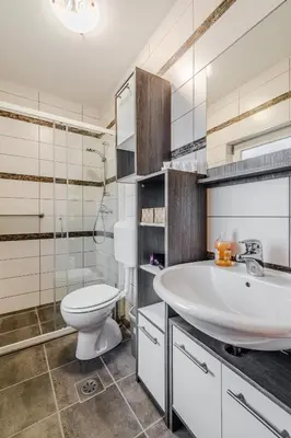 a bathroom with a white sink and a toilet at Penzion Hosnar in Bovec