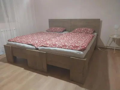 a bed with a wooden headboard and red pillows on it at at Silva's place in Ptuj