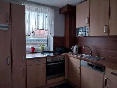a kitchen with wooden cabinets and a sink and a window at at Silva's place in Ptuj