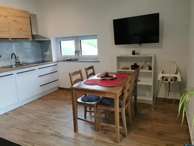 a kitchen and dining room with a table and chairs at Apartma Lipa in Veliki Gaber