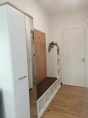 a room with white walls and a wooden shelf at Apartma Lipa in Veliki Gaber