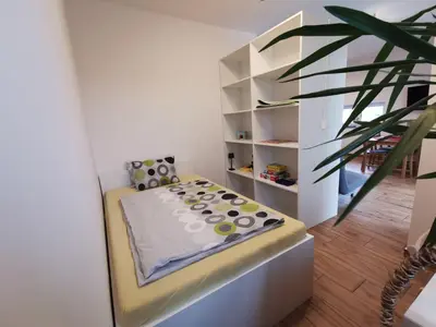 a room with a bed and a plant at Apartma Lipa in Veliki Gaber