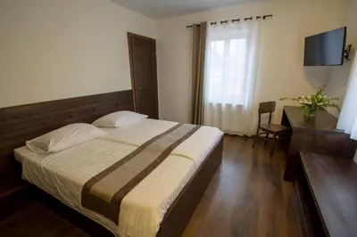a bedroom with a bed and a desk and a television at Smrekarjeva Domačija in Postojna