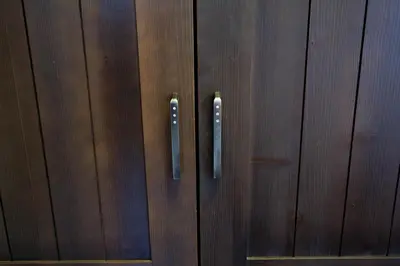 two metal door handles on a wooden wall at Smrekarjeva Domačija in Postojna