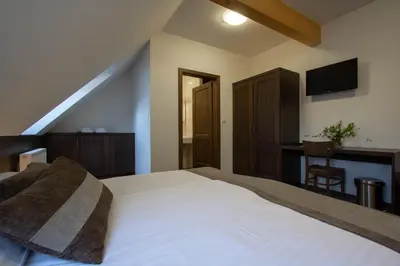 a bedroom with a bed and a desk with a television at Smrekarjeva Domačija in Postojna