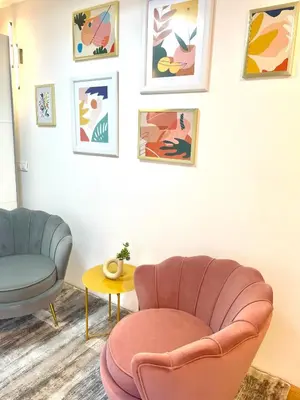 a living room with a pink chair and a table at Topel dom v središču mesta in Maribor