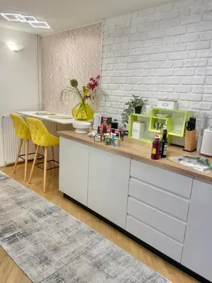 a kitchen with white cabinets and yellow chairs at Topel dom v središču mesta in Maribor