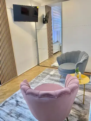 a living room with a purple chair and a table at Topel dom v središču mesta in Maribor