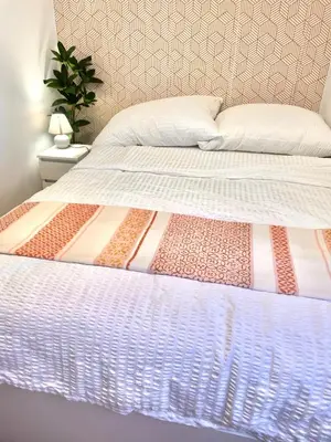 a bed with a comforter on top of it at Topel dom v središču mesta in Maribor