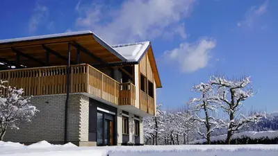 a house with a balcony in the snow at Hiša na Hribu- A Peaceful Hilltop Escape above river Kolpa in Kostel