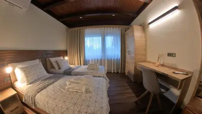 a bedroom with two beds and a desk in it at Hiša na Hribu- A Peaceful Hilltop Escape above river Kolpa in Kostel