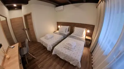 a bedroom with two beds and a window at Hiša na Hribu- A Peaceful Hilltop Escape above river Kolpa in Kostel