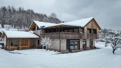 a large wooden house with snow on top of it at Hiša na Hribu- A Peaceful Hilltop Escape above river Kolpa in Kostel
