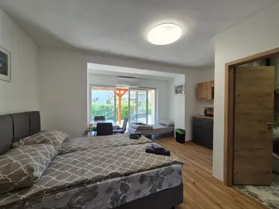 a bedroom with a bed and a living room at Villa Vojkova in Ljubljana