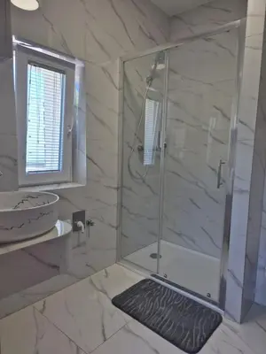 a bathroom with a shower with a glass door at Villa Vojkova in Ljubljana