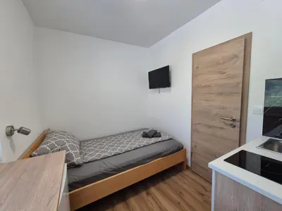 a small bedroom with a bed and a sink at Villa Vojkova in Ljubljana