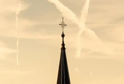 a steeple of a building with a cross on it at Pinia City Centre Modern Studio with Shared Bathroom in Ljubljana