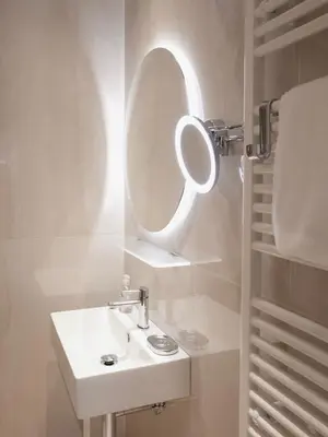 a bathroom with a sink and a mirror at Pinia City Centre Modern Studio with Shared Bathroom in Ljubljana
