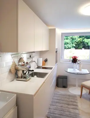a kitchen with white cabinets and a sink and a window at Pinia City Centre Modern Studio with Shared Bathroom in Ljubljana